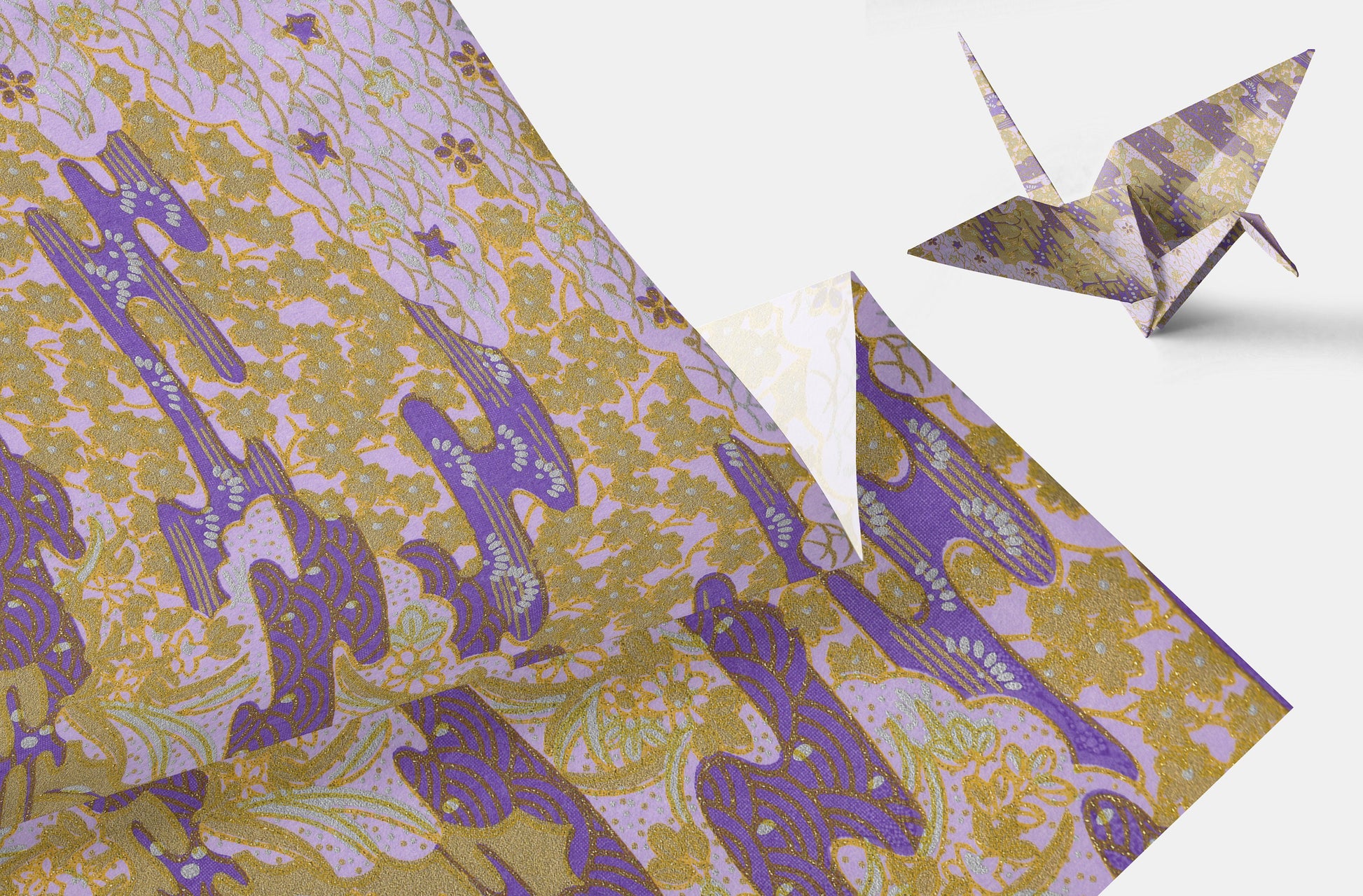 Patterned paper with purple guitar design and a folded paper crane on a white background