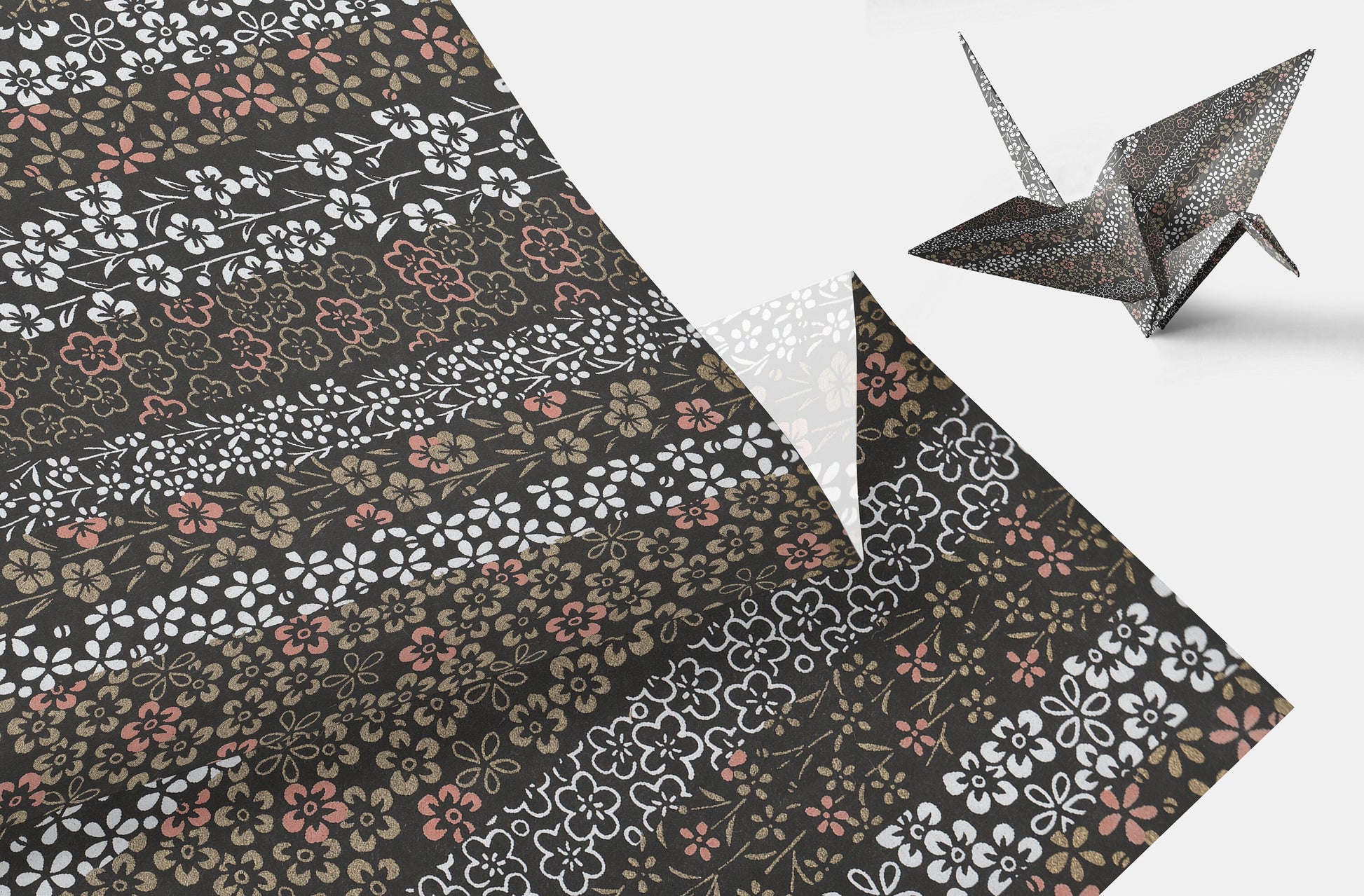 Floral-patterned paper with a folded paper crane on a white background
