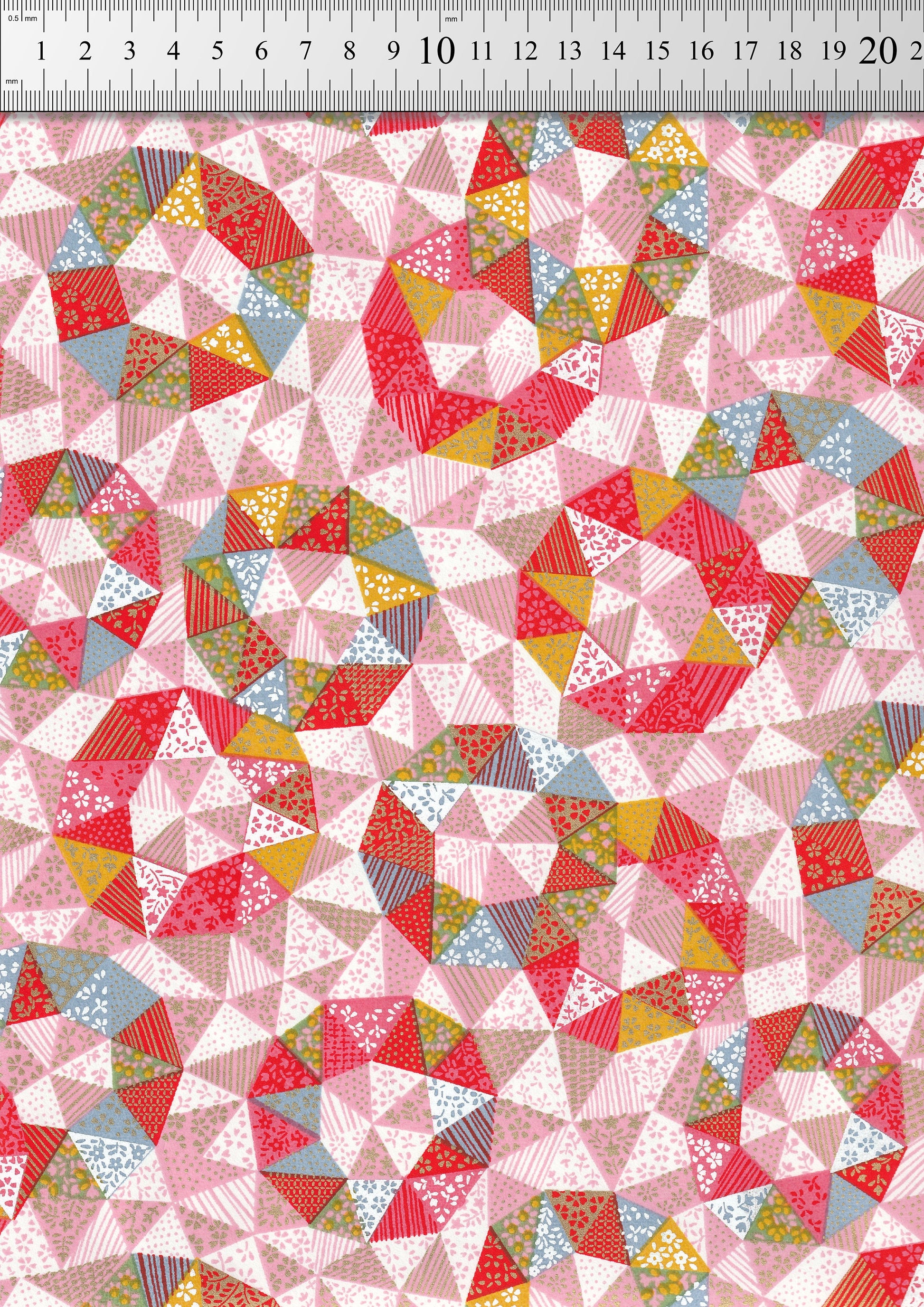 Colorful geometric triangle pattern fabric with a ruler at the top for scale.