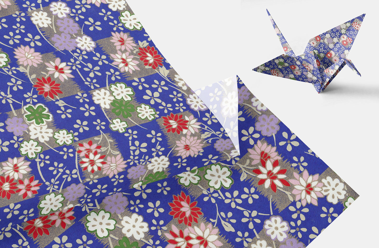 Floral-patterned chiyogami paper with a folded paper crane on a white background