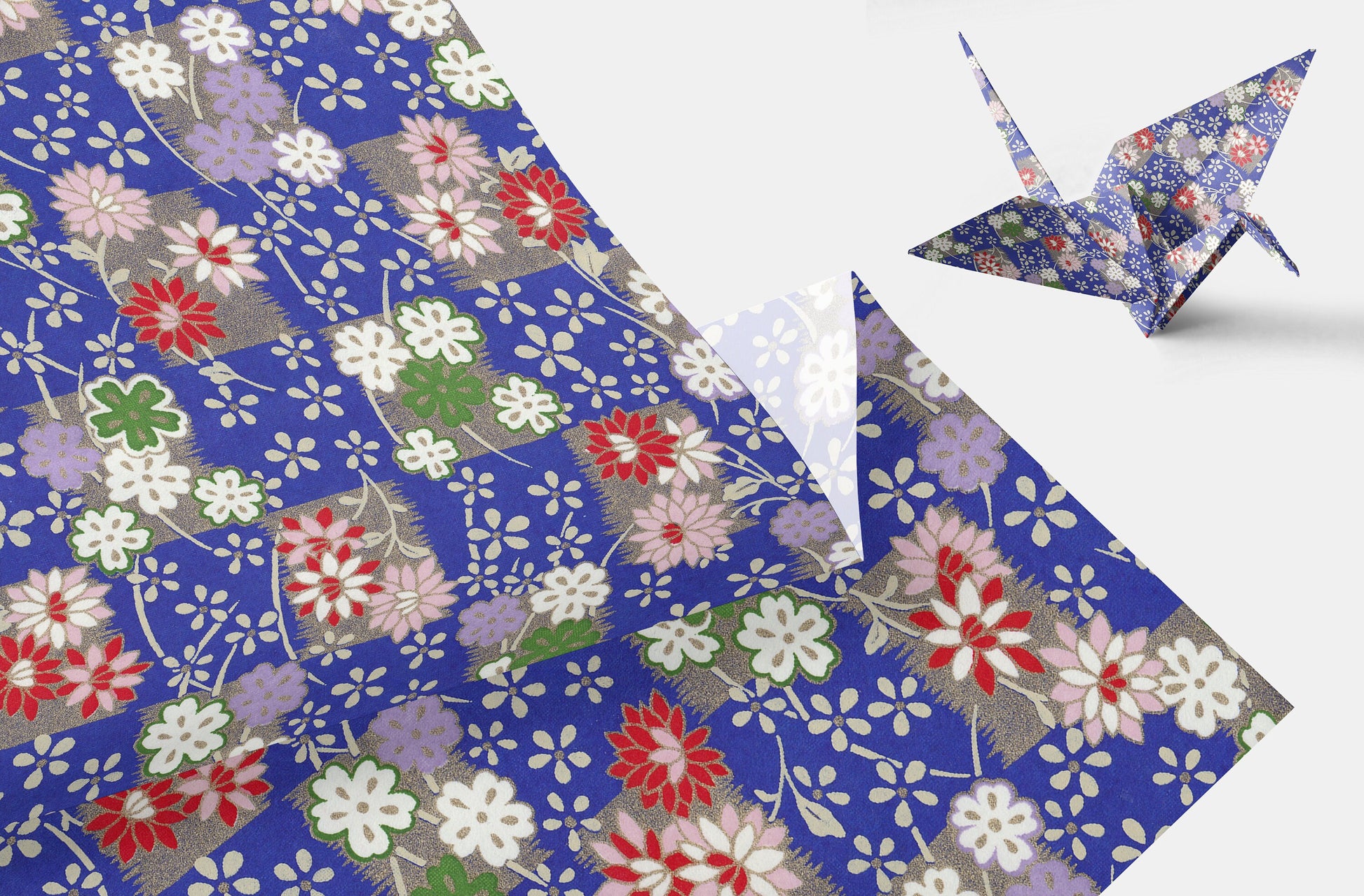 Floral-patterned chiyogami paper with a folded paper crane on a white background
