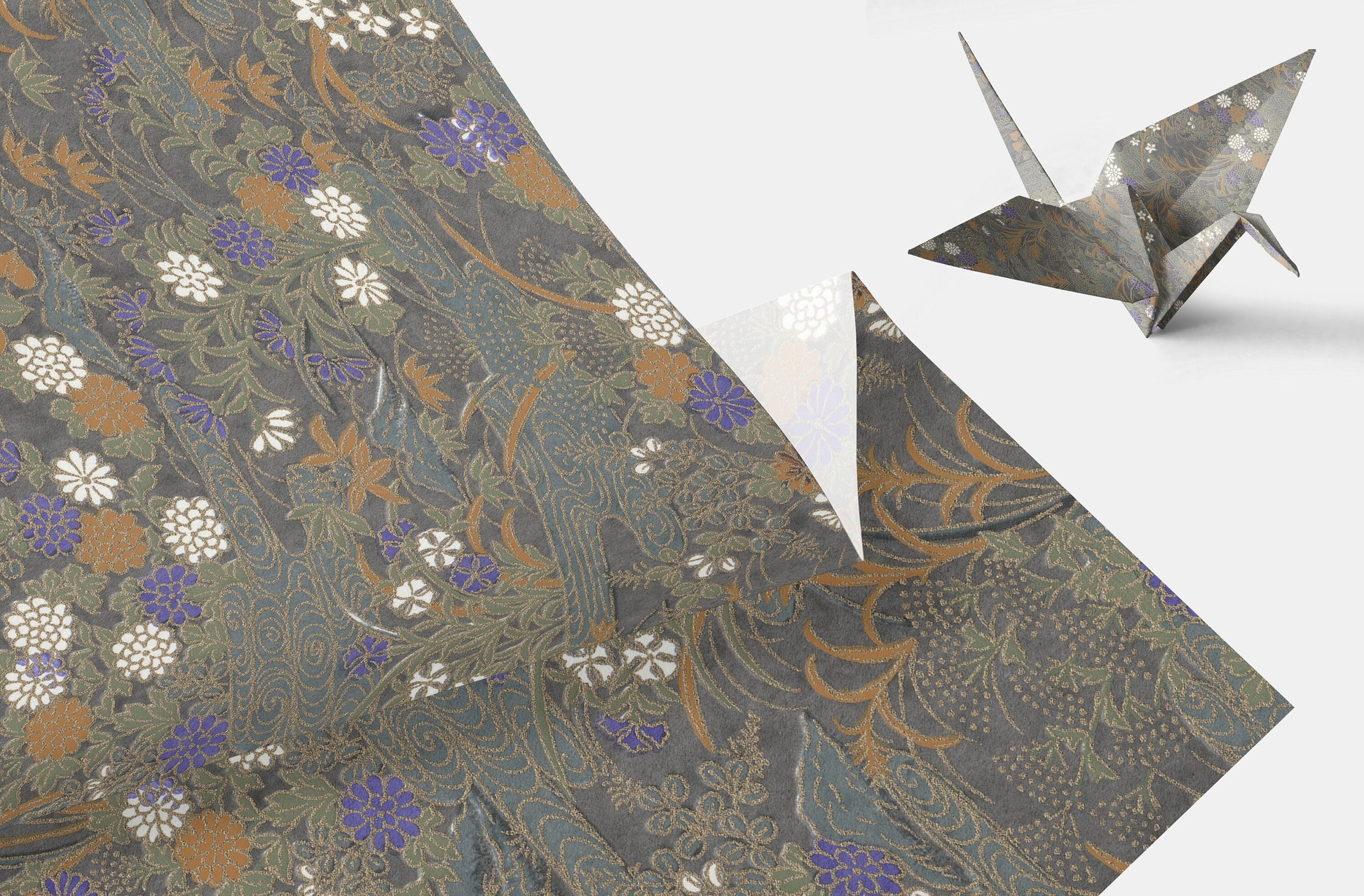 Decorative chiyogami paper with floral pattern and a folded origami crane on a white background