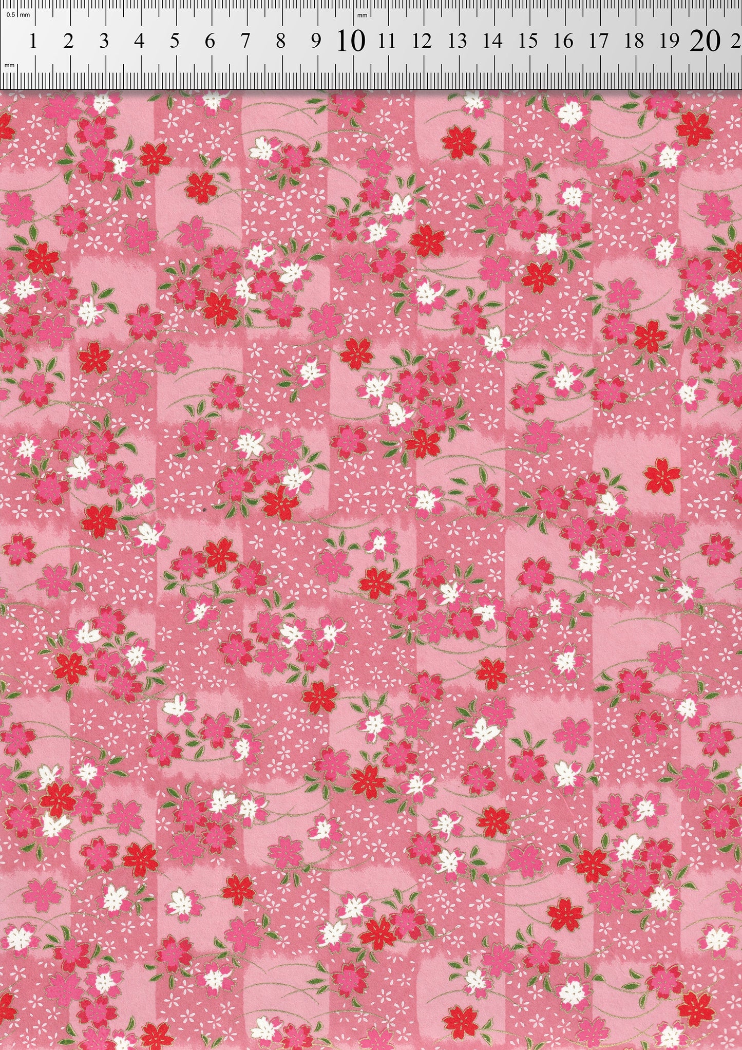 Floral pattern chiyogami paper with small flowers on a pink background and a ruler for scale