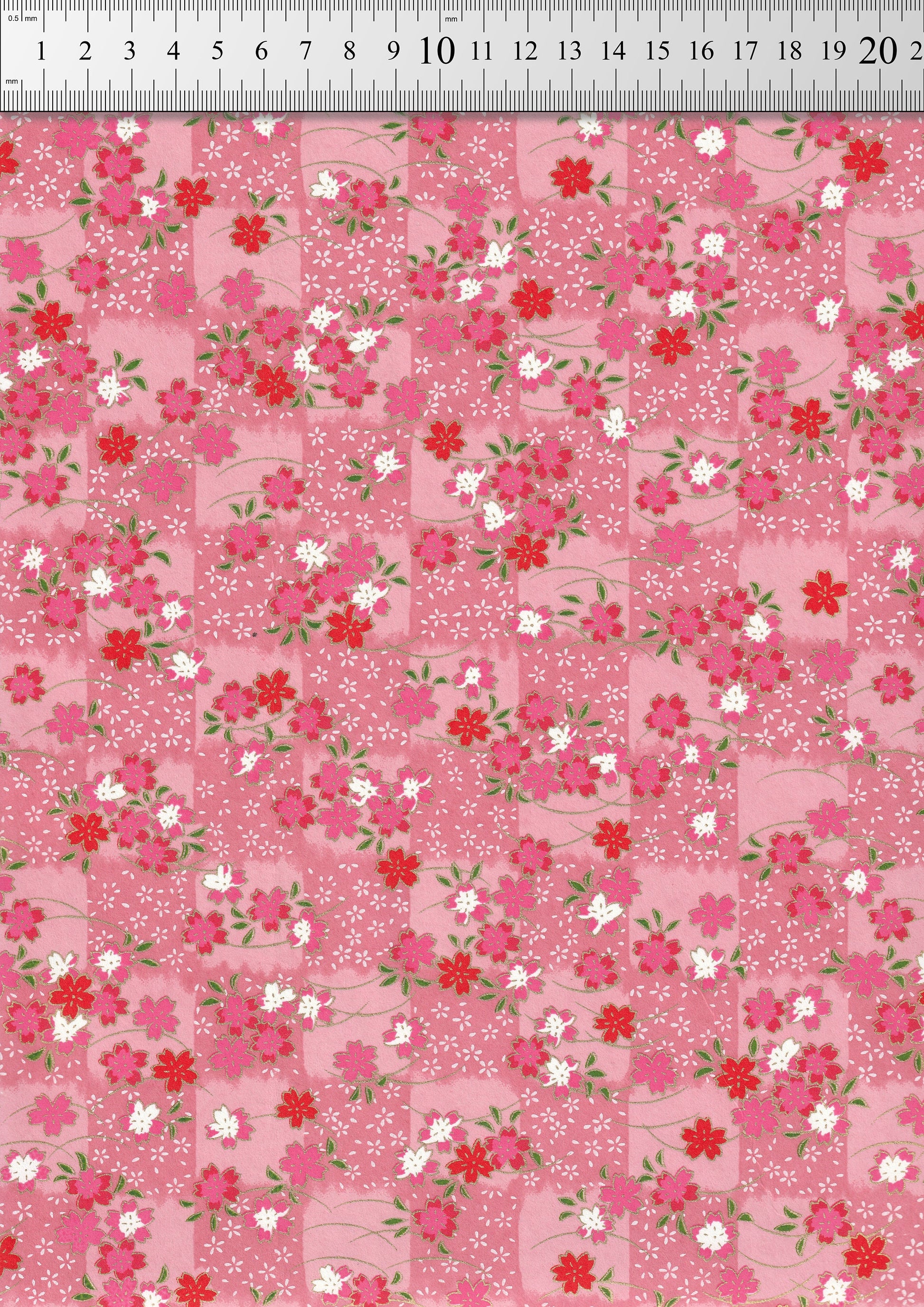 Floral pattern chiyogami paper with small flowers on a pink background and a ruler for scale
