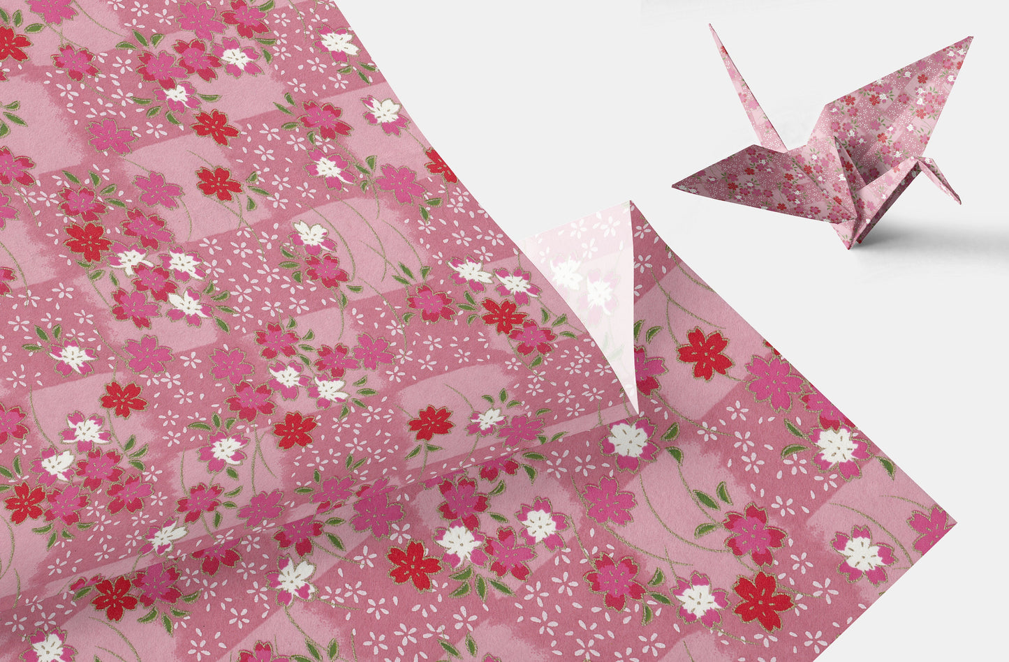Pink floral-patterned chiyogami paper with a folded paper crane on a white background