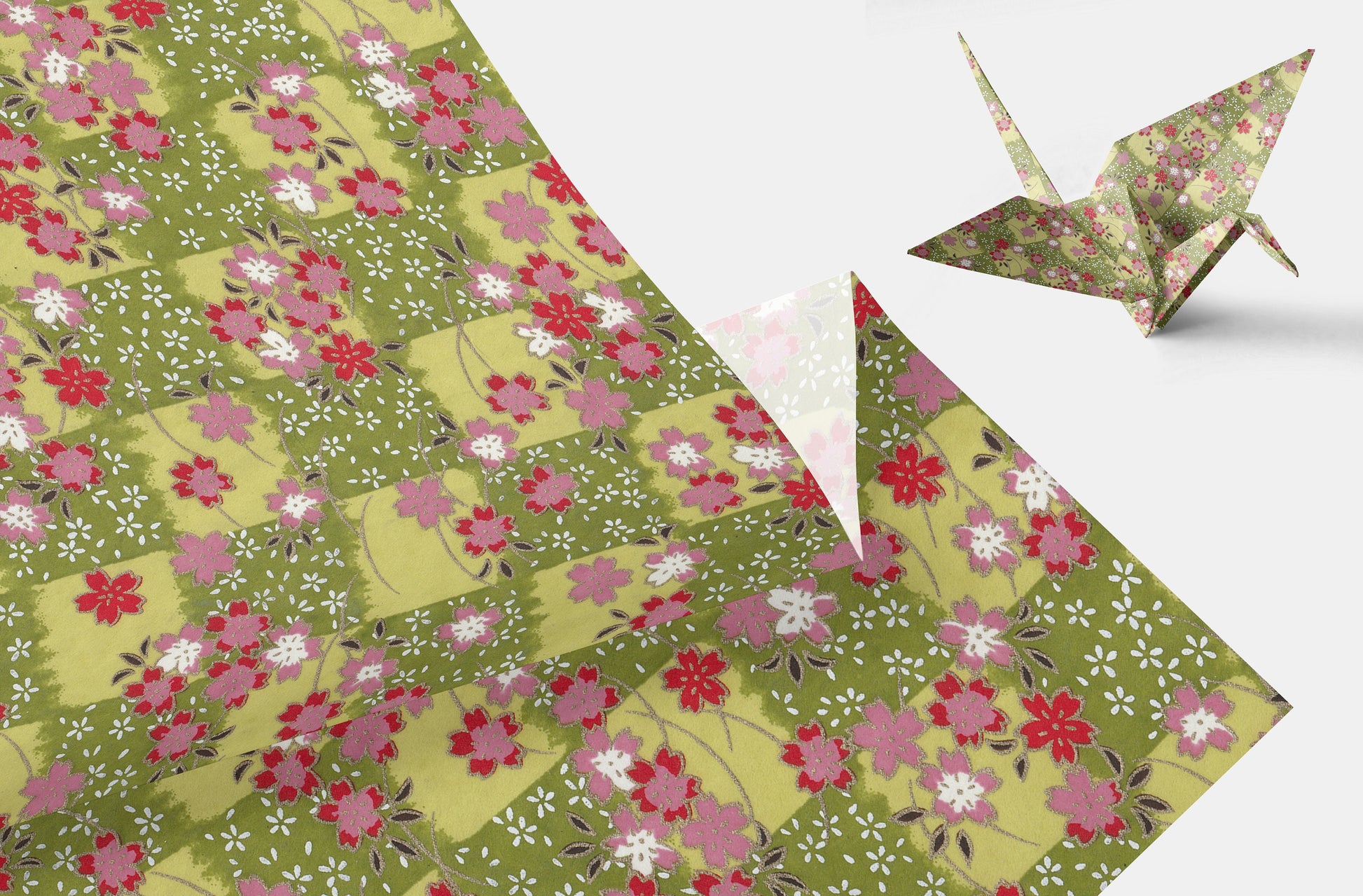Floral-patterned paper with a folded paper crane on a white background