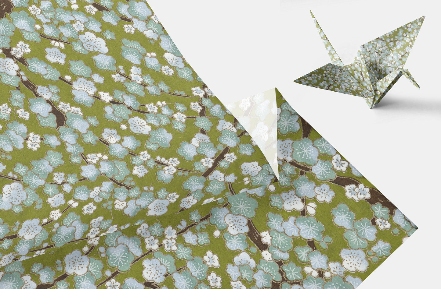 Green floral-patterned paper with a folded origami crane on a white background