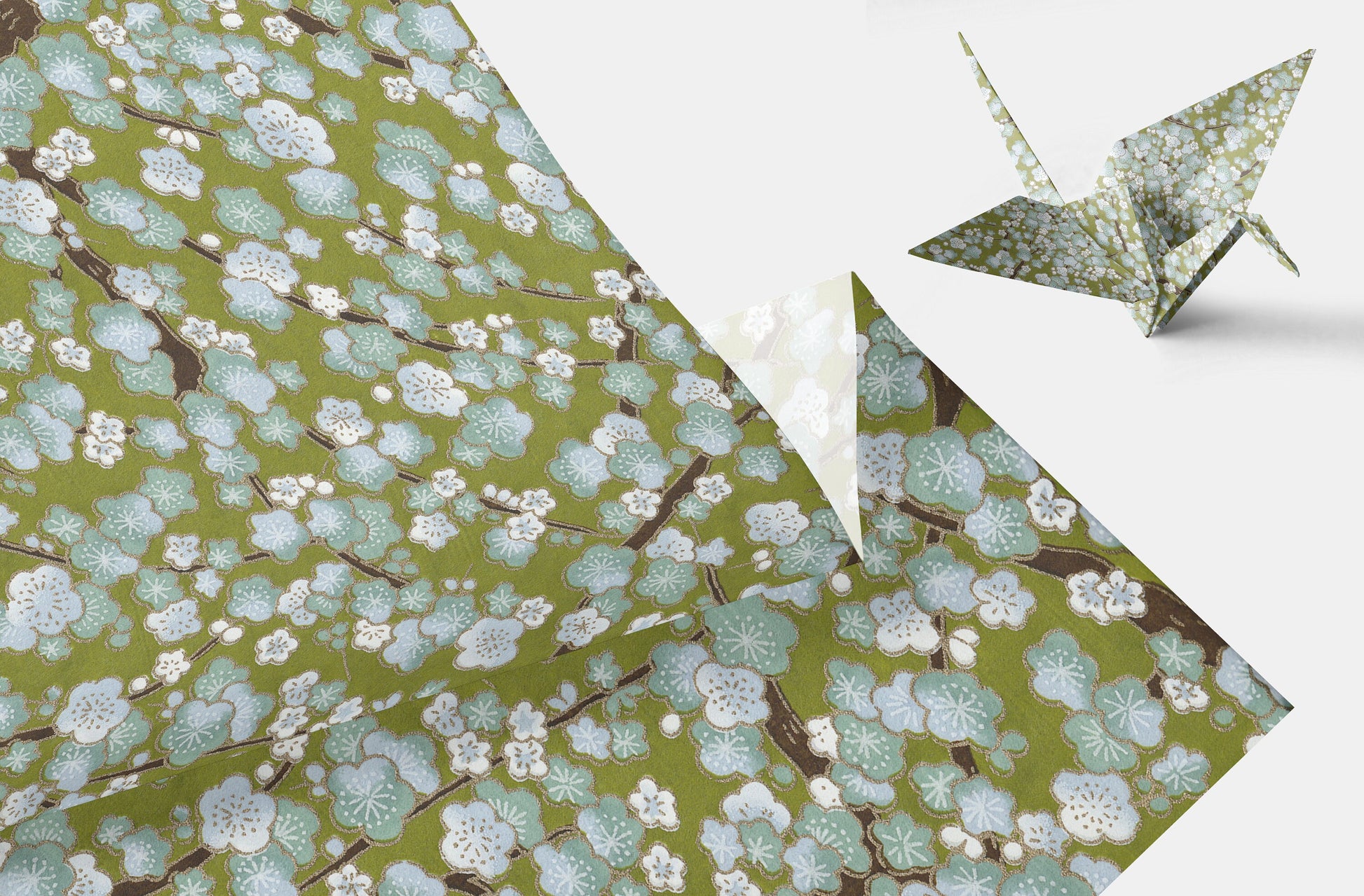 Green floral-patterned paper with a folded origami crane on a white background