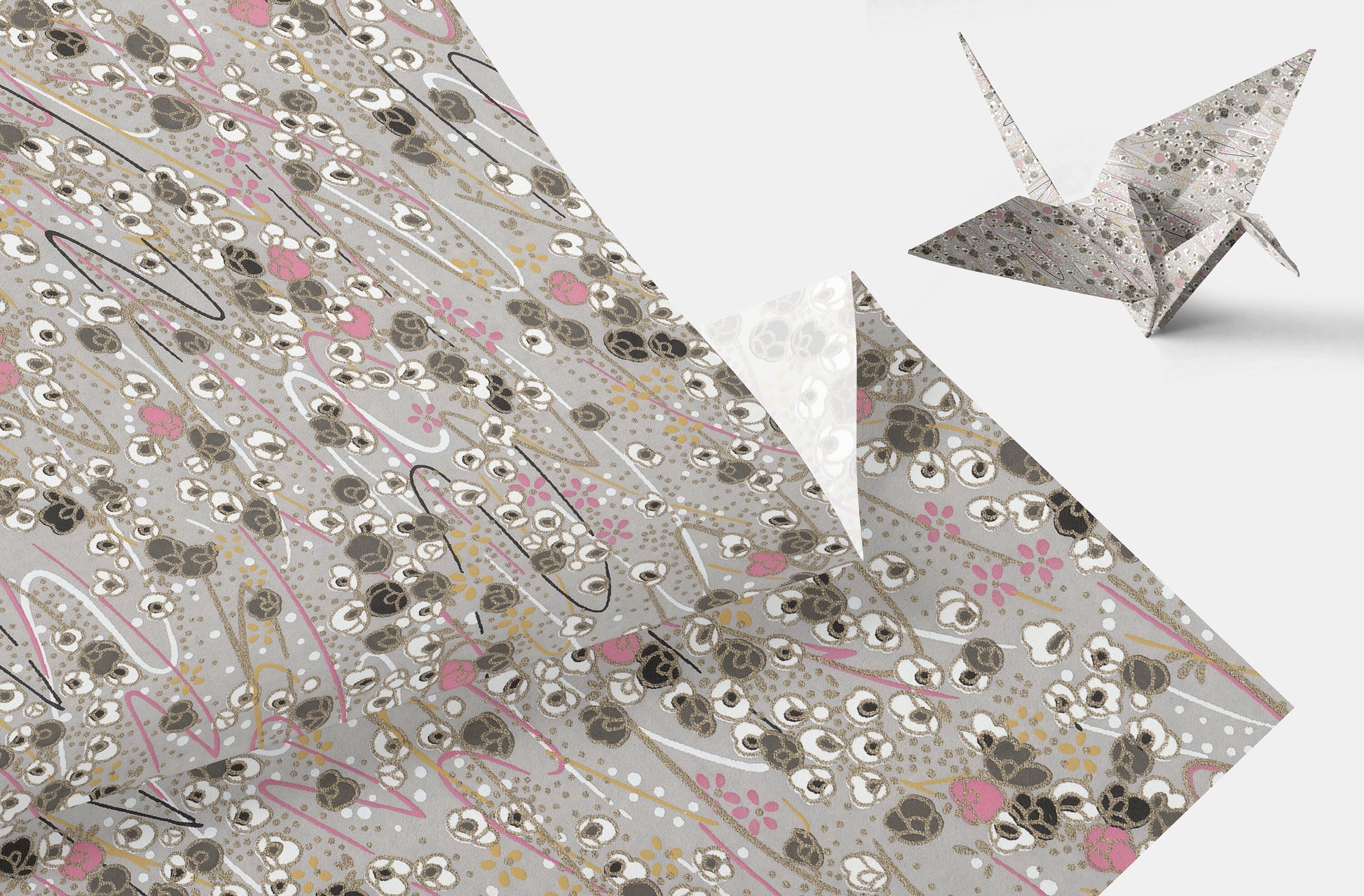 Decorative paper with floral pattern and a folded paper crane on a white background