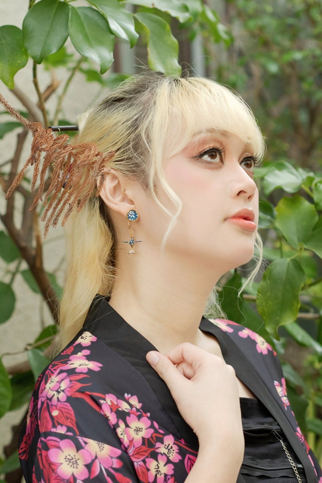 Model wearing handmade origami crane and cabochon earrings by Leverras Art